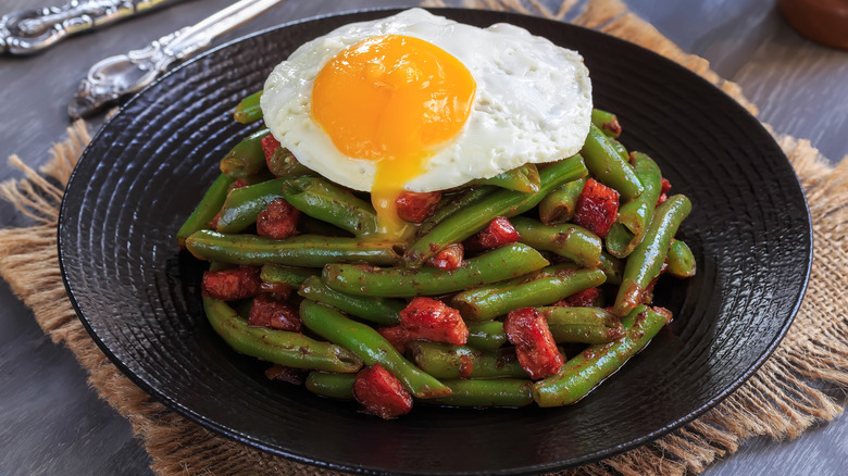 Runny fried egg on stir fry dish