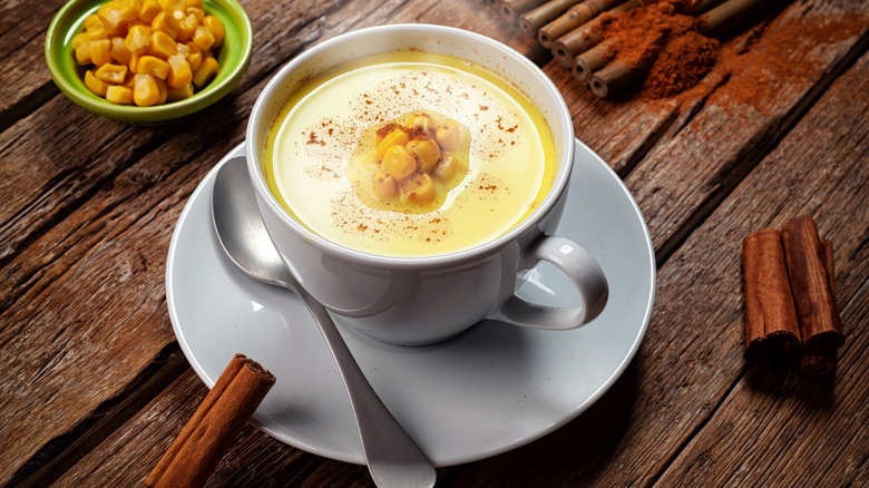 cup of corn milk with cinnamon sticks