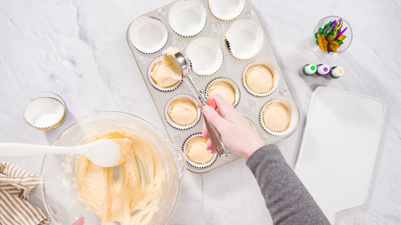 hand spooning cupcake batter