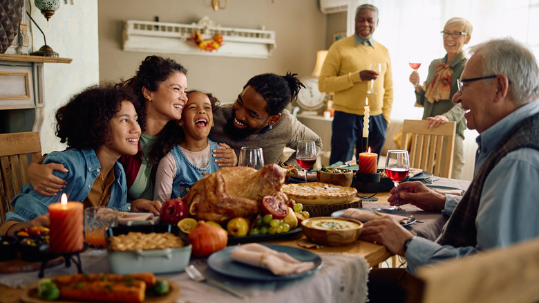 Happy family around the table at Thanksgiving.