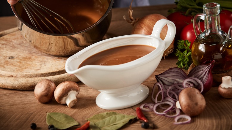 White gravy boat surrounded by veggies