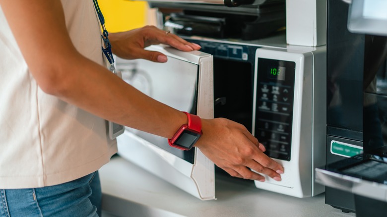 woman opening microwave