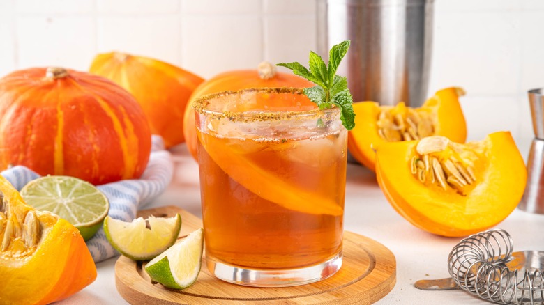 Pumpkin spice margarita with pumpkins in the background