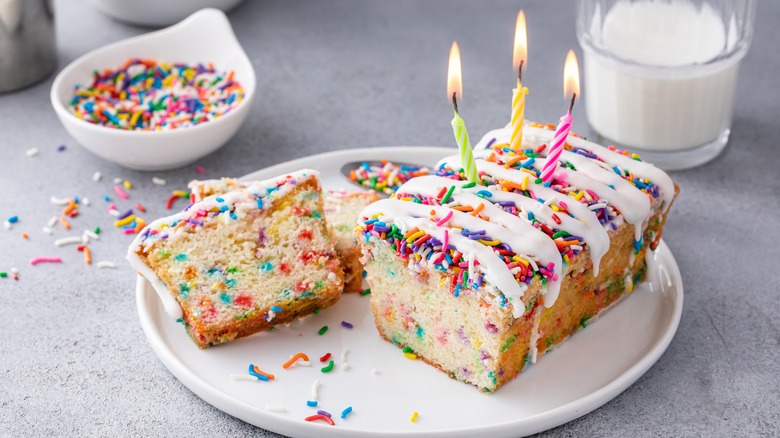 sliced birthday cake with candles