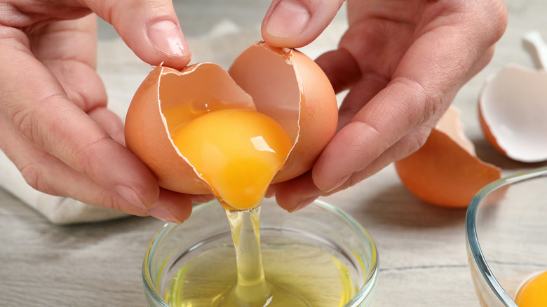 Woman separating egg yolk from egg whites