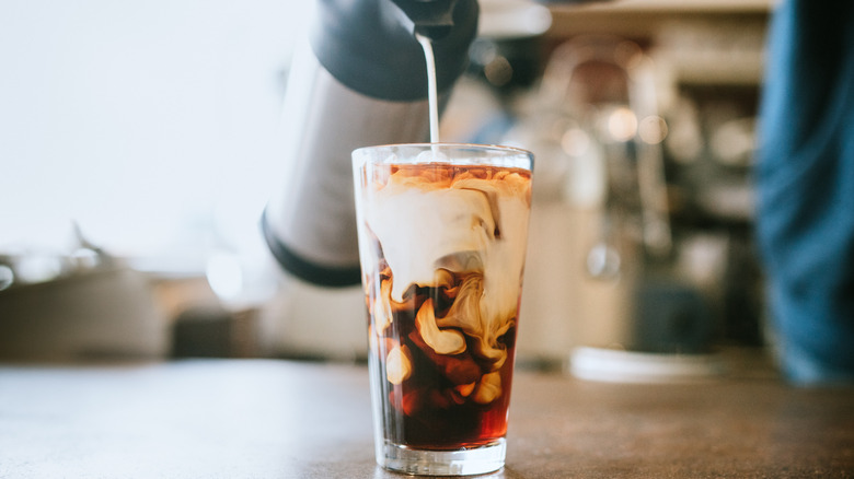 Pouring cream into coffee