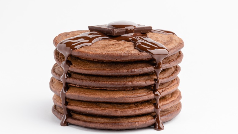 Stack of hot chocolate pancakes against a white background