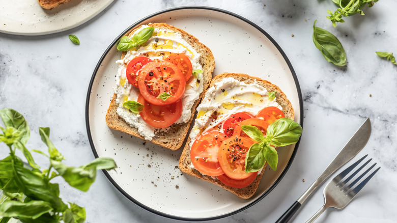 open-face tomato sandwich on white plate