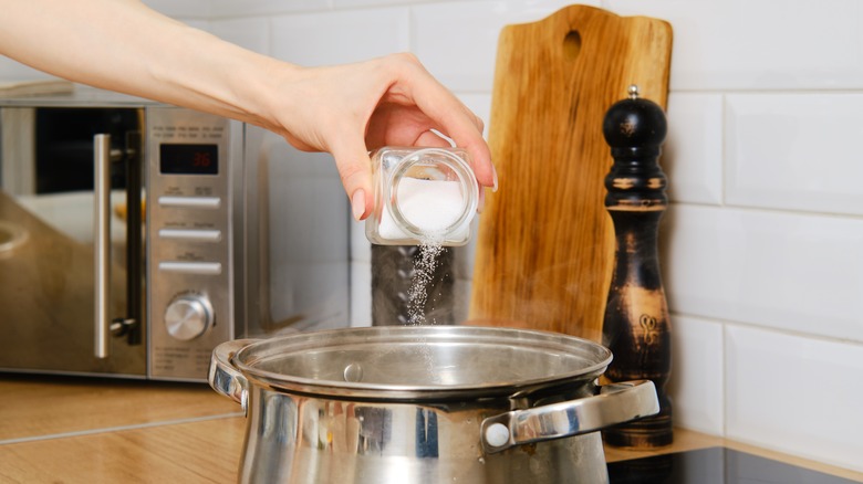 cook sprinkling salt into pot