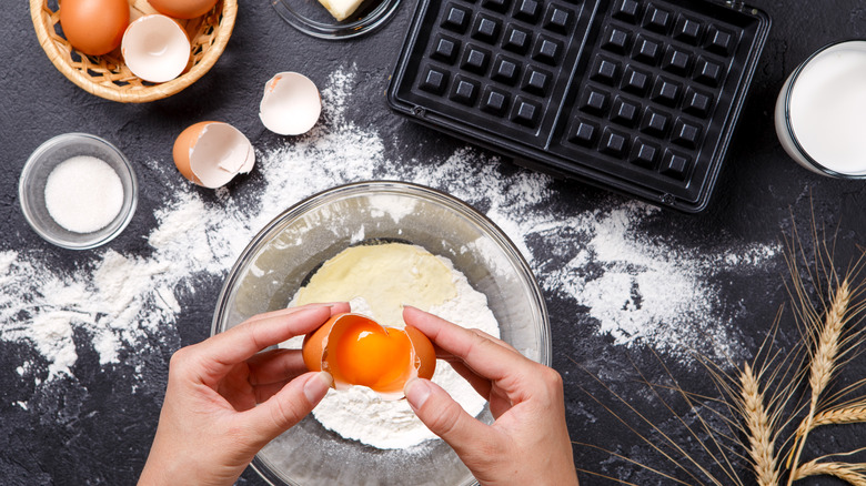 cracking egg into waffle batter