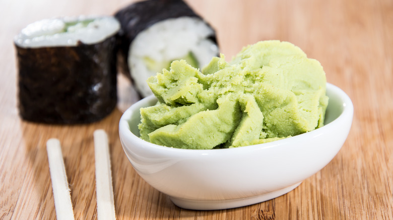 wasabi on wooden table with chopsticks and sushi