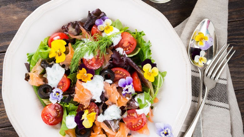 salmon salad with edible flowers in bowl