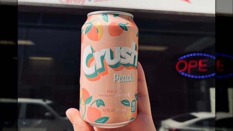 Person holding Crush peach soda