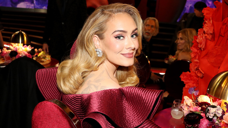 Adele sitting at a table smiling into the camera at the Grammy Awards