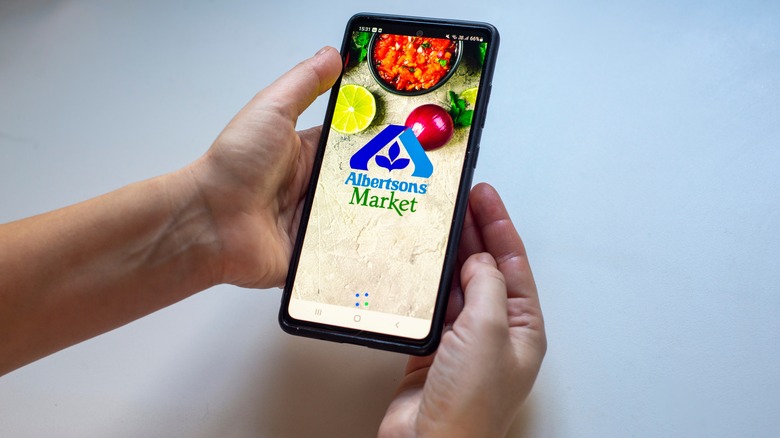 hands holding a smartphone showing the Albertsons app