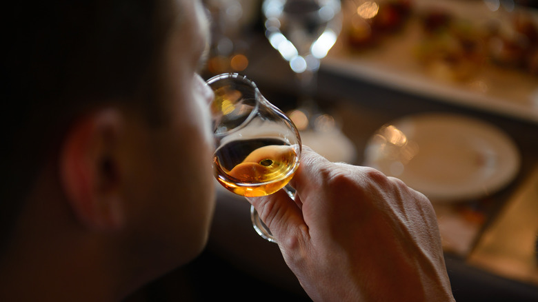man smelling a glass of cognac