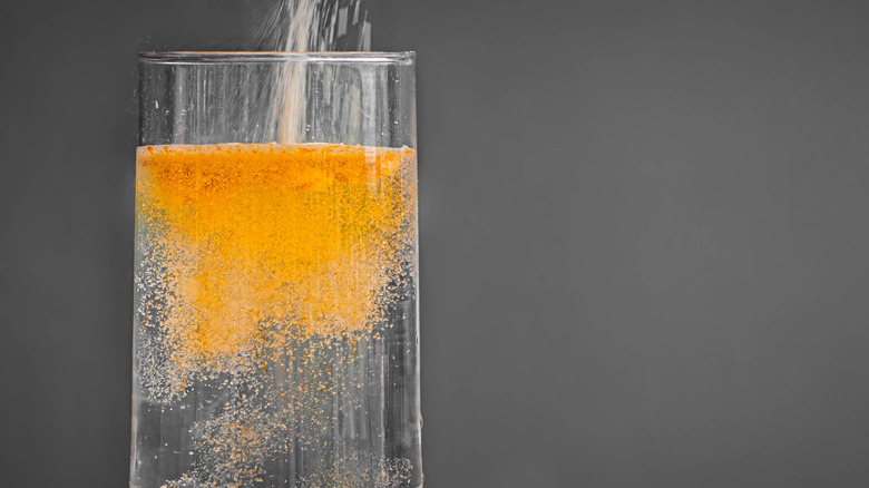 Orange seltzer pouring into glass