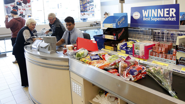 Cashier helping customers at Aldi