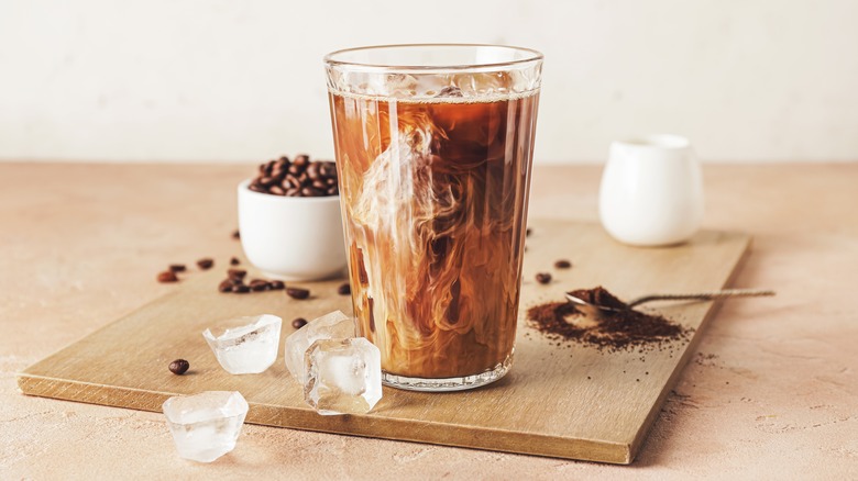 Glass of cold brew and coffee beans on a table