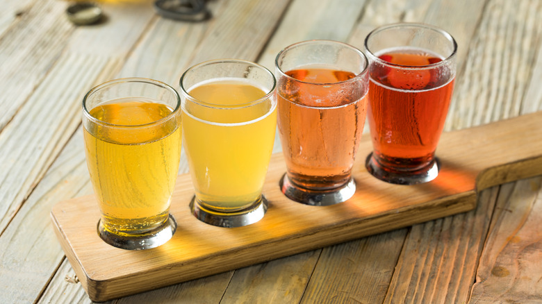 assorted hard ciders on wooden serving tray