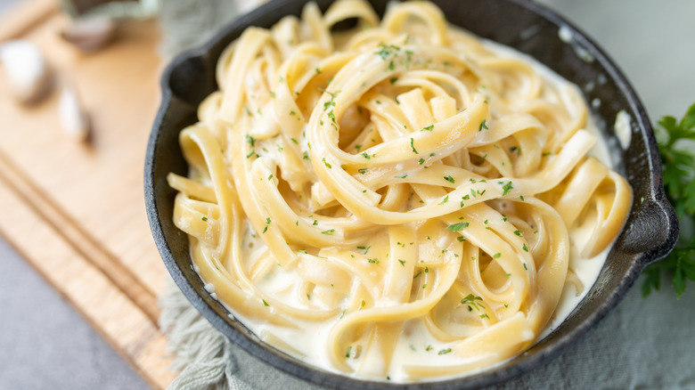 Alfredo pasta in black bowl