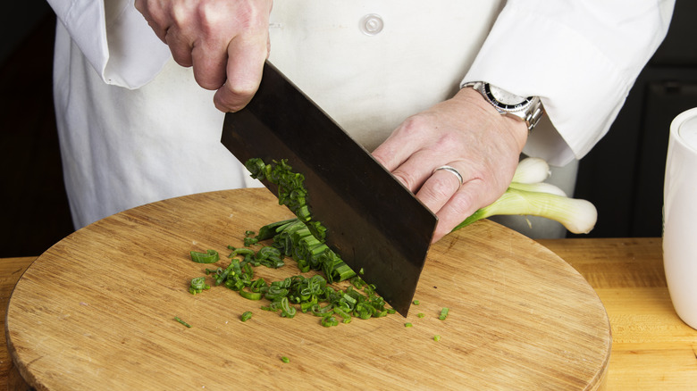 chef chopping green onions with a Chinese chef's knife