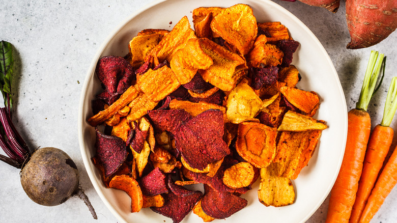 Homemade vegetable chips in bowl with veggies