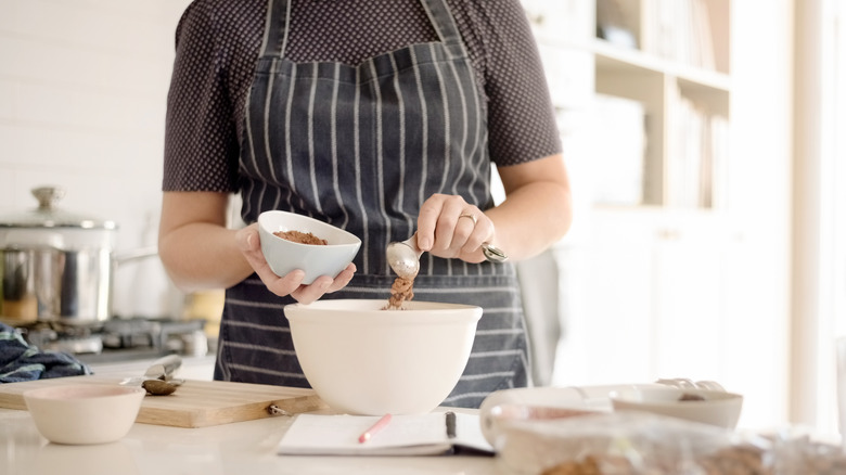 adding hot chocolate mix in mixing bowl