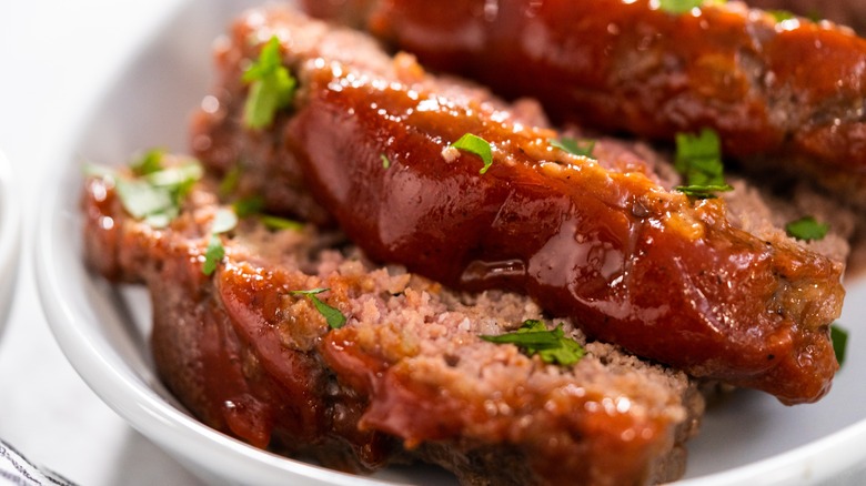 Glazed meatloaf slices on white plate