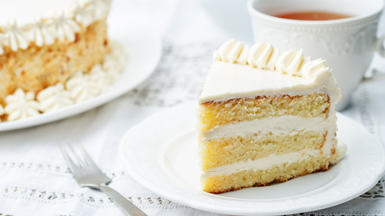 Slice of vanilla cake with buttercream layers and tea