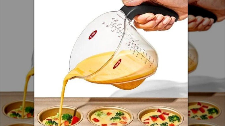 Person pouring mixture from OXO measuring cup