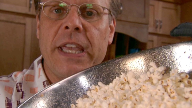 Alton Brown holding popcorn bowl