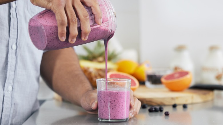 purple smoothie being poured into glass