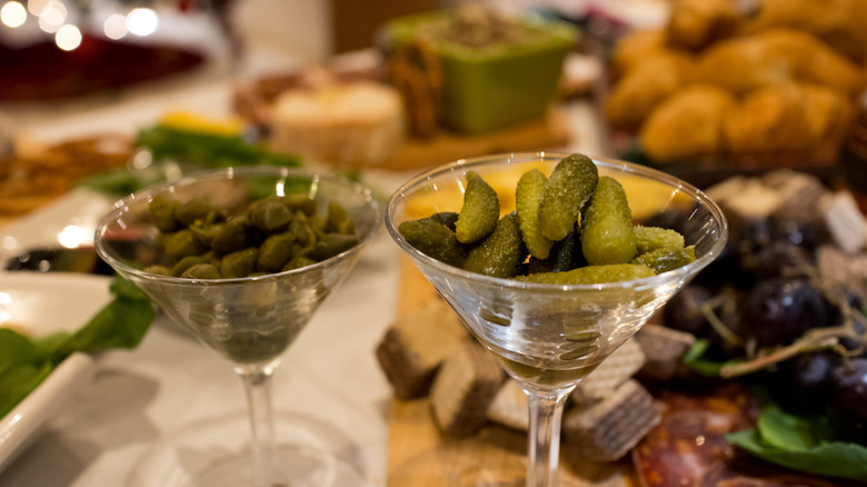 Pickles in martini glass with snacks