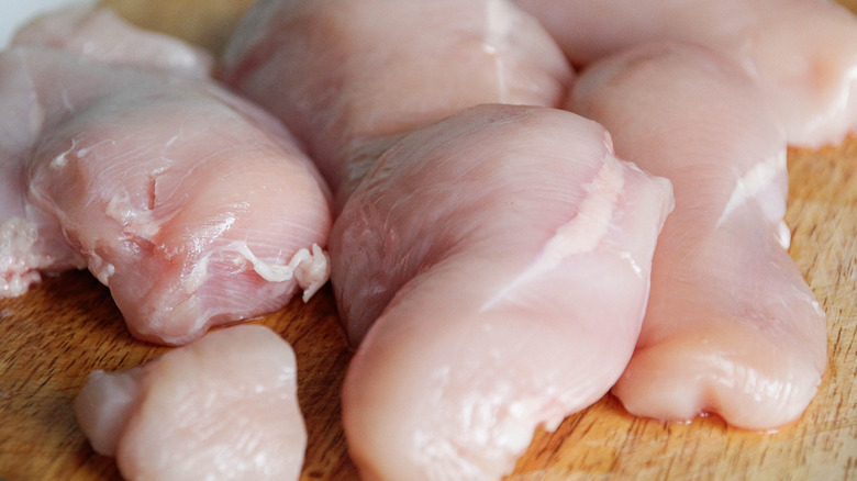 raw chicken breasts on a cutting board