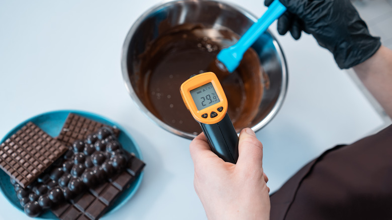 Close-up of chocolatier monitoring the temperature while tempering chocolate