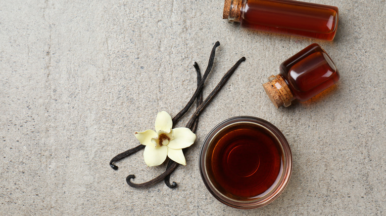 Vanilla extract in jars with beans and flower