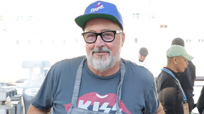 Andrew Zimmern in ball cap and glasses