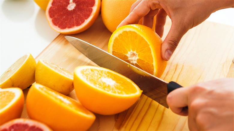 Knife cutting through orange 