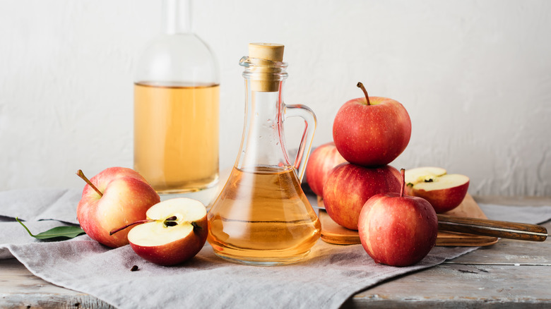 Apple cider vinegar in decanter with apples