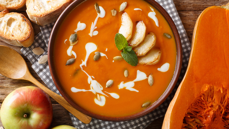 bowl of butternut squash and apple soup with apple and squash