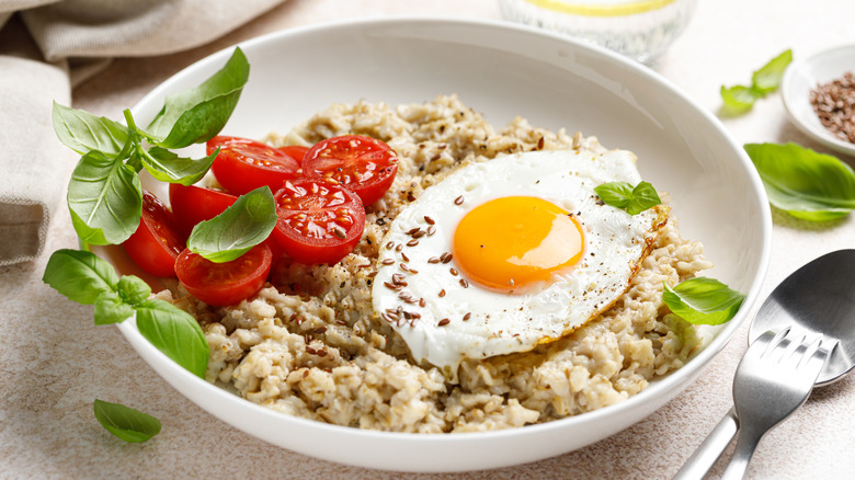 Eggs, tomato, and greens on bed of oatmeal