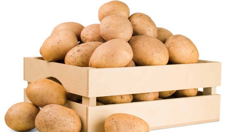 raw potatoes in wooden crate