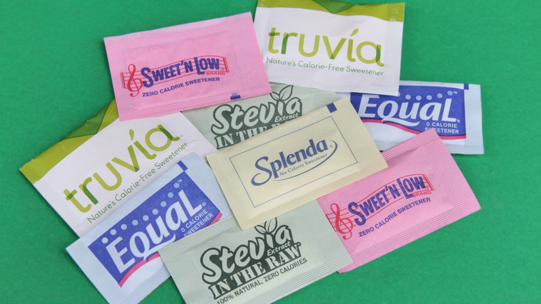 Assorted artificial sweetener packets on a green table