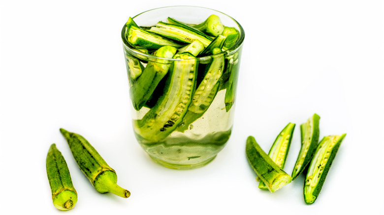 A glass of water with sliced okra