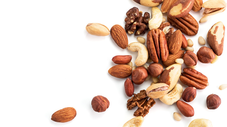 a variety of raw nuts on white background