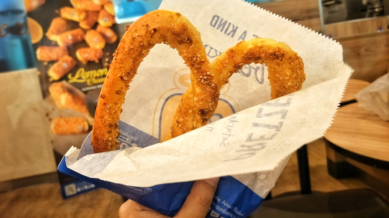 Hand holding Auntie Anne's pretzel