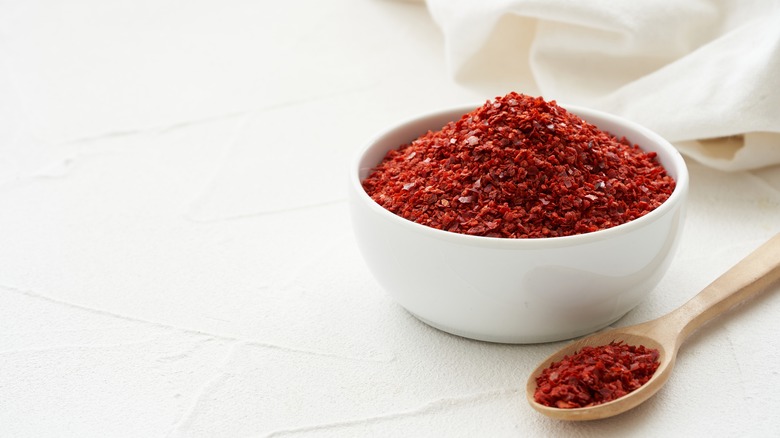 Chili flakes in white bowl with spoon