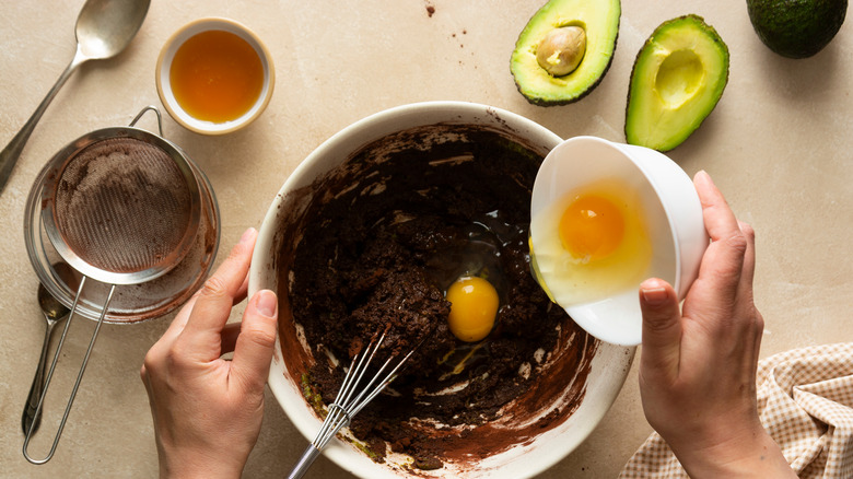 Preparing brownie batter in mixing bowl with avocadoes 