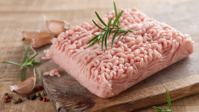 Ground chicken on a wooden cutting board